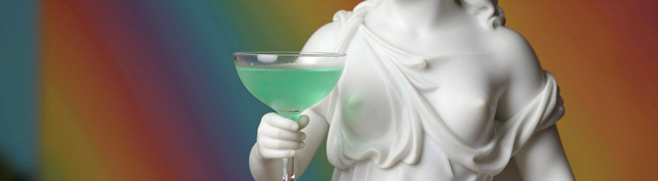 white marble sculpture aphrodite holding frosted glass containing bright green cocktail set vibrant