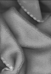 Soft fleece blanket folds in grayscale macro texture scan © MariaEduarda