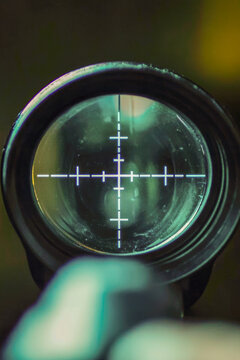 A person examining something through a telescope or binoculars, ideal for use in scientific, educational or military contexts. vertical frame