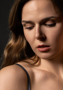 Young woman looking down with closed eyes, showing contemplation and natural beauty