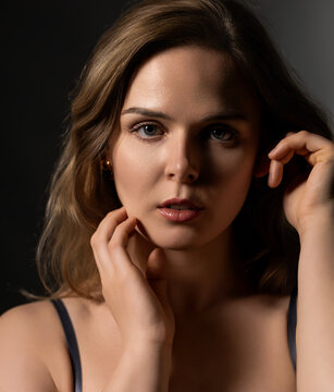 Young woman posing for a portrait with soft light and a dark background