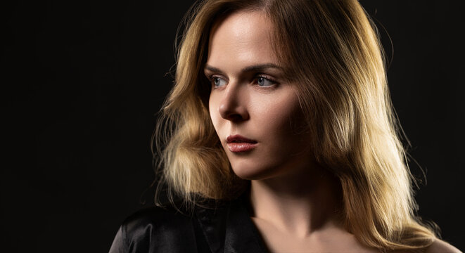 Woman's profile with light blonde hair and blue eyes, expressing thoughtful look