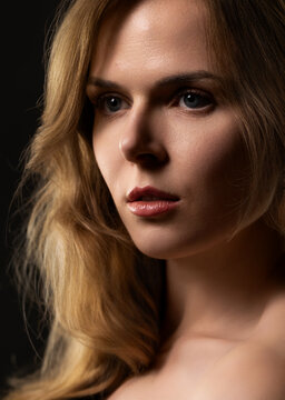 Young woman's close up portrait with blonde hair, blue eyes, and natural makeup