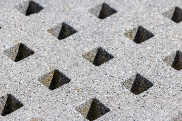 Fototapeta premium Square holes in concrete wall with light and shadow patterns, abstract architectural background texture