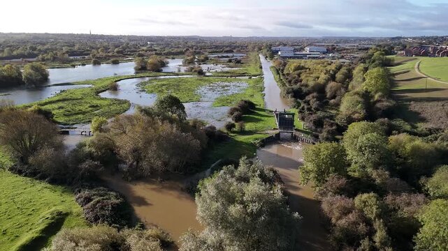 Aerial View of River Nene Weir and Lock Structure with Town Skyline in Background