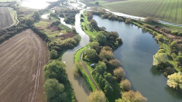 Aerial forward flight along River Nene with parallel railway and farmland Northamptonshire England