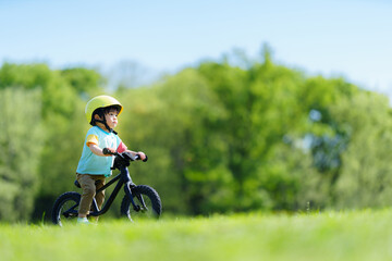 Obraz premium キックバイクで公園を走る2歳の男の子