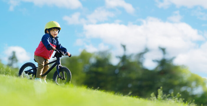 公園でキックバイクを練習する2歳の男の子