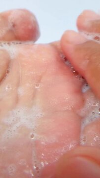 Showing soap foam on palm and rubbing with both hands. Close up view, hand hygiene concept, cleansing bubbles for daily skincare.