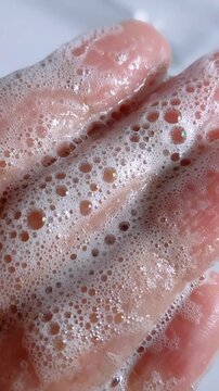 Extreme close up of palm covered in soap bubble foam. Hand hygiene, white cleansing bubbles, soft lather texture for daily wash.