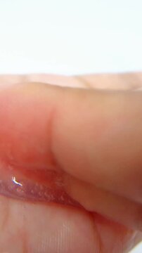 Clear gel liquid on palm of hand. Close up of transparent bubbly fluid. White background, skincare or cosmetic texture concept.