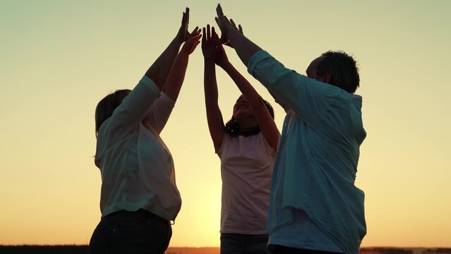 Business people raising their hands, team success group unity. Teamwork, business. Partners raise hands in gesture cooperation, achieving team goal result. People united by common idea. Outdoors, sky
