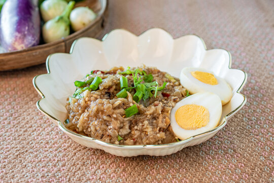 Healthy Thai pounded eggplant salad with boiled egg and herbs. Known as Tam Ma Khua in Northern Thailand or Soup Ma Khua in Isan, representing authentic regional Asian rustic home-cooked dining.