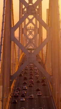 Traffic driving across the Bay Bridge towards downtown San Francisco at sunset. Vertical Video.