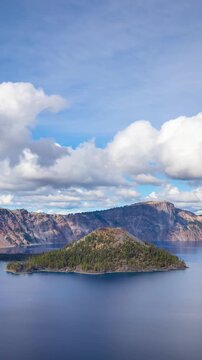 Time lapse of puffy clouds moving across the sky above Crater Lake in Oregon. Vertical video.