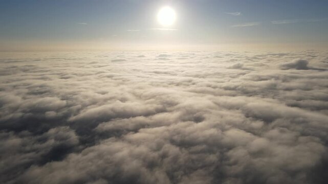 Aerial shot of the sunrise above a layer of clouds