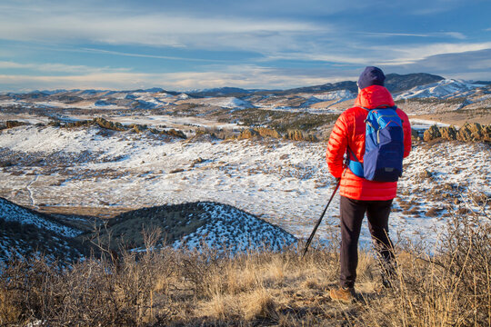 male hiker reaching top of a hill at foothills of Rocky Mountains - winter scenery at Devil's Backbone Open Space near Loveland, Colorado