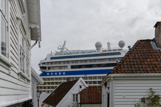 Blick auf &uuml;ber die D&auml;cher der Altstadt Stavanger auf ein Kreuzfahrschiff im Hafen