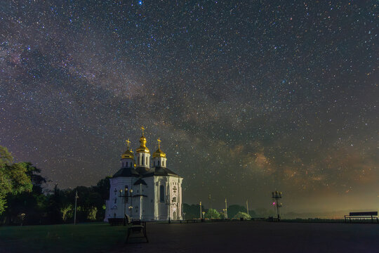 the Catherine's Church in Chernihiv under a majestic starry sky featuring the luminous Milky Way galaxy