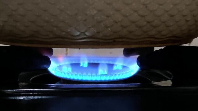 Close Up of Blue Flame Burning on a Domestic Gas Stove Under a Pot