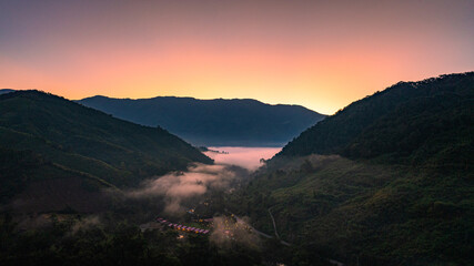 Naklejka premium A radiant sunrise slowly brightens the mountain horizon, revealing rolling ridges touched by warm golden light. The shifting colors and soft morning glow create a calm, breathtaking time lapse scene.