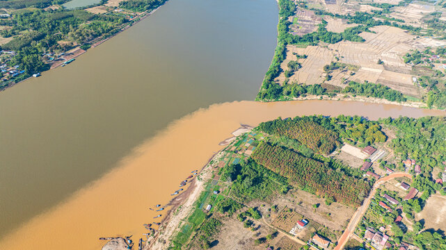 High angle view of contrasting river colors blending gradually along the Mekong, symbolizing the confluence of different water sources.