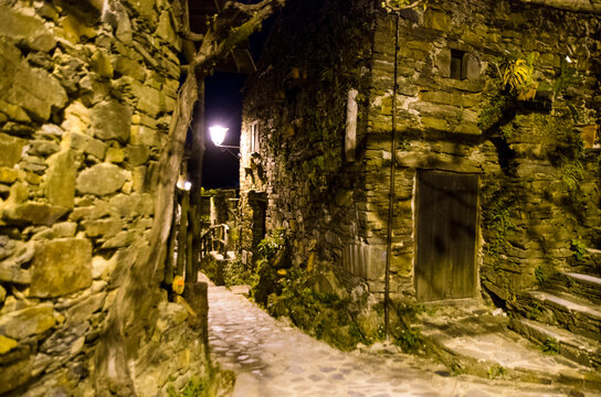 Narrow night street between stone houses in Talasnal, Portugal