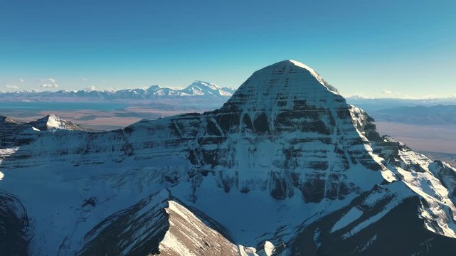 Aerial view of snow-covered Mount Kailash above the Tibetan Plateau under clear blue sky