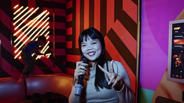 Asian woman singing karaoke in a private party room