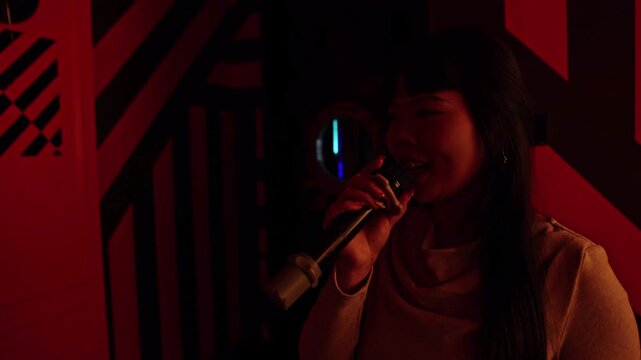 Asian woman singing karaoke in a private room