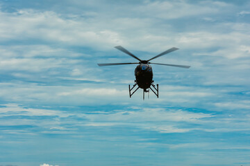 Helicopter flying against dramatic cloudy blue sky with cinematic mood, representing aviation, transportation, travel, aerial observation, and modern air mobility concept. © tabahzaman