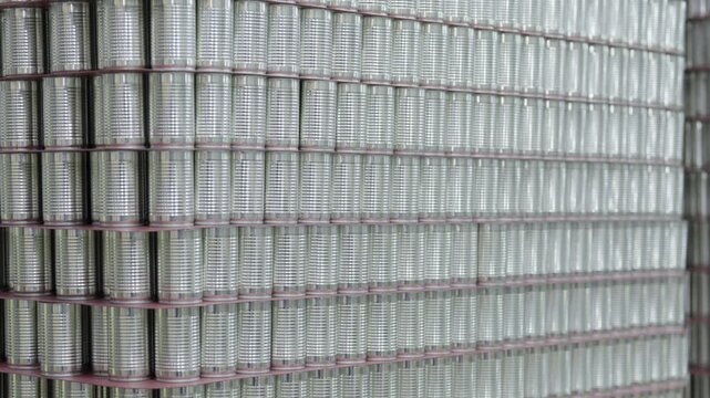 Food factory automated production line, stacked metal can wall texture industrial storage pattern silver tin can rows repetitive cylindrical container surface abstract metal background metal canister