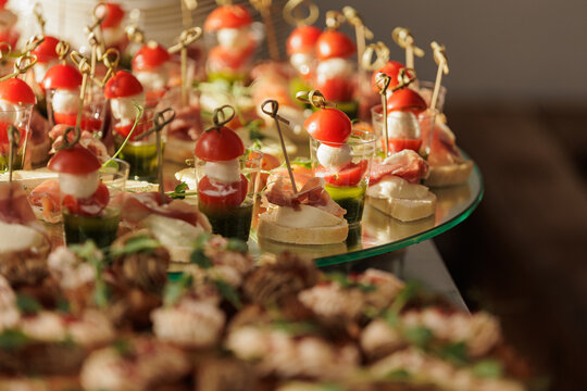 Assorted caprese skewers and prosciutto canap&eacute;s on catering tray
