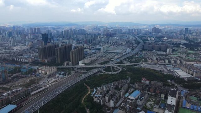 Aerial view of Kunming city skyline with highway interchange and railway station in Kunming, Yunnan, China
