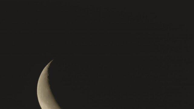 (HDR PQ 2100 10bit 4:2:2) - 4K Video Rising Crescent Moon Before Dawn with Atmospheric Color Shift from Orange to Yellow in Low Altitude.