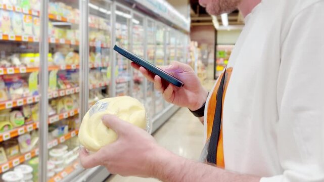 Young man shopping in supermarket, reading product information	