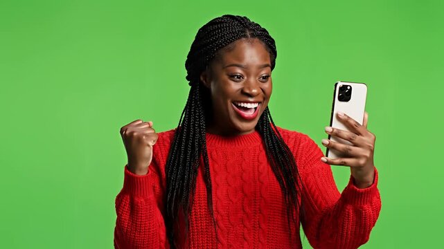 Young Black Woman Reacts with Surprise and Joy to Smartphone Content.