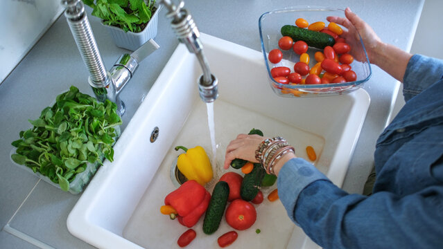 Woman Washing Bright Vegetables Over Sink