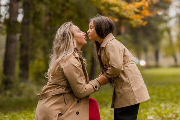 Fototapeta premium mother and daughter walking in the park in autumn