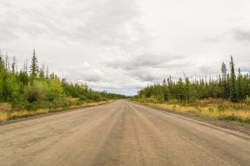 Fototapeta premium Empty Gravel Road Vanishing into Boreal Forest Wilderness in Northern British Columbia, Canada