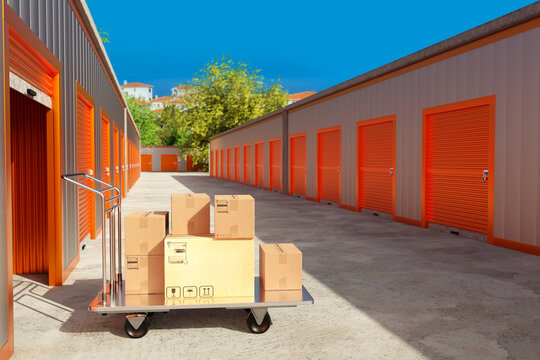 Self storage facility corridor with rental units, moving cart, and cardboard boxes for relocation and secure personal storage