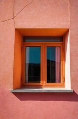 Obraz premium Portrait of orange window on pink wall background 