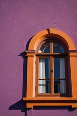 Obraz premium Portrait of orange window on purple wall background 