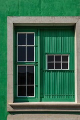 Obraz premium Portrait of green window on green wall background 