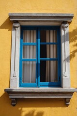 Obraz premium Portrait of blue window on yellow wall background 