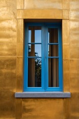Obraz premium Portrait of blue window on gold wall background 