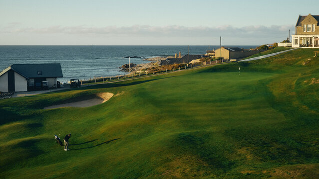 view of the golf course by the sea at sunset