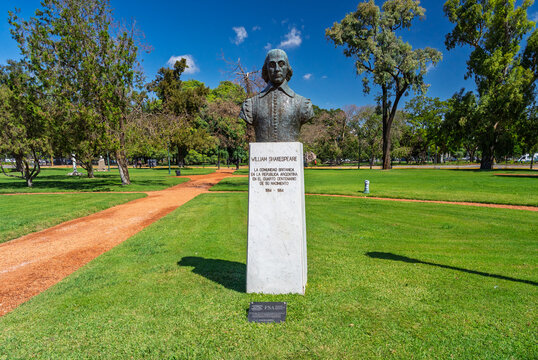 Bronze bust of the famous English poet and playwright William Shakespeare on a white marble pedestal in a green public park under a clear blue sky, Buenos Aires, Argentina