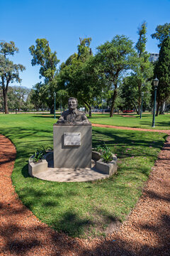 Bronze bust monument of writer Gabriel Garcia Marquez in a public park with green grass and trees under a clear blue sky, Buenos Aires, Argentina