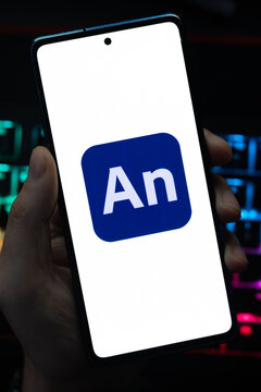Punta Arenas, Chile &ndash; May 18, 2026: A person holding a smartphone that displays the Adobe Animate software logo on its screen, with a blurry multi-colored backlit keyboard in the background